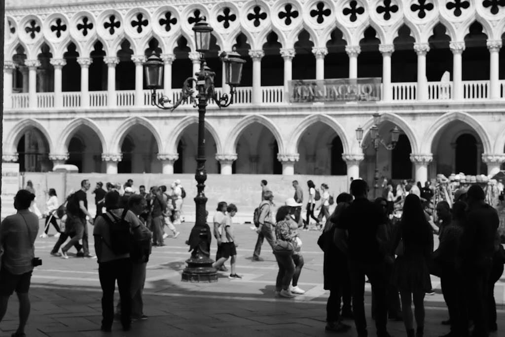 Black and white photo of people walking in a courtyard